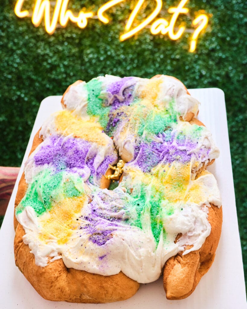 king cake in front of neon sign.