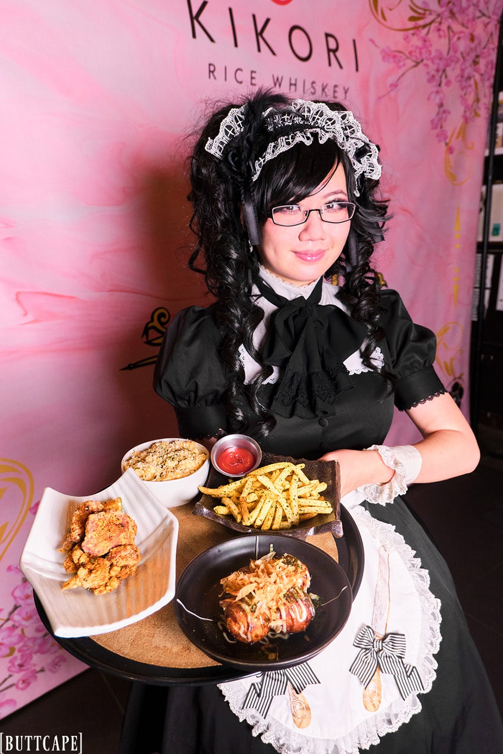 maid holding a tray of food.