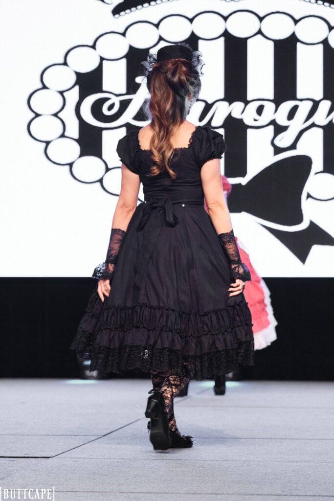 lolita model wearing all black classic dress walking away.