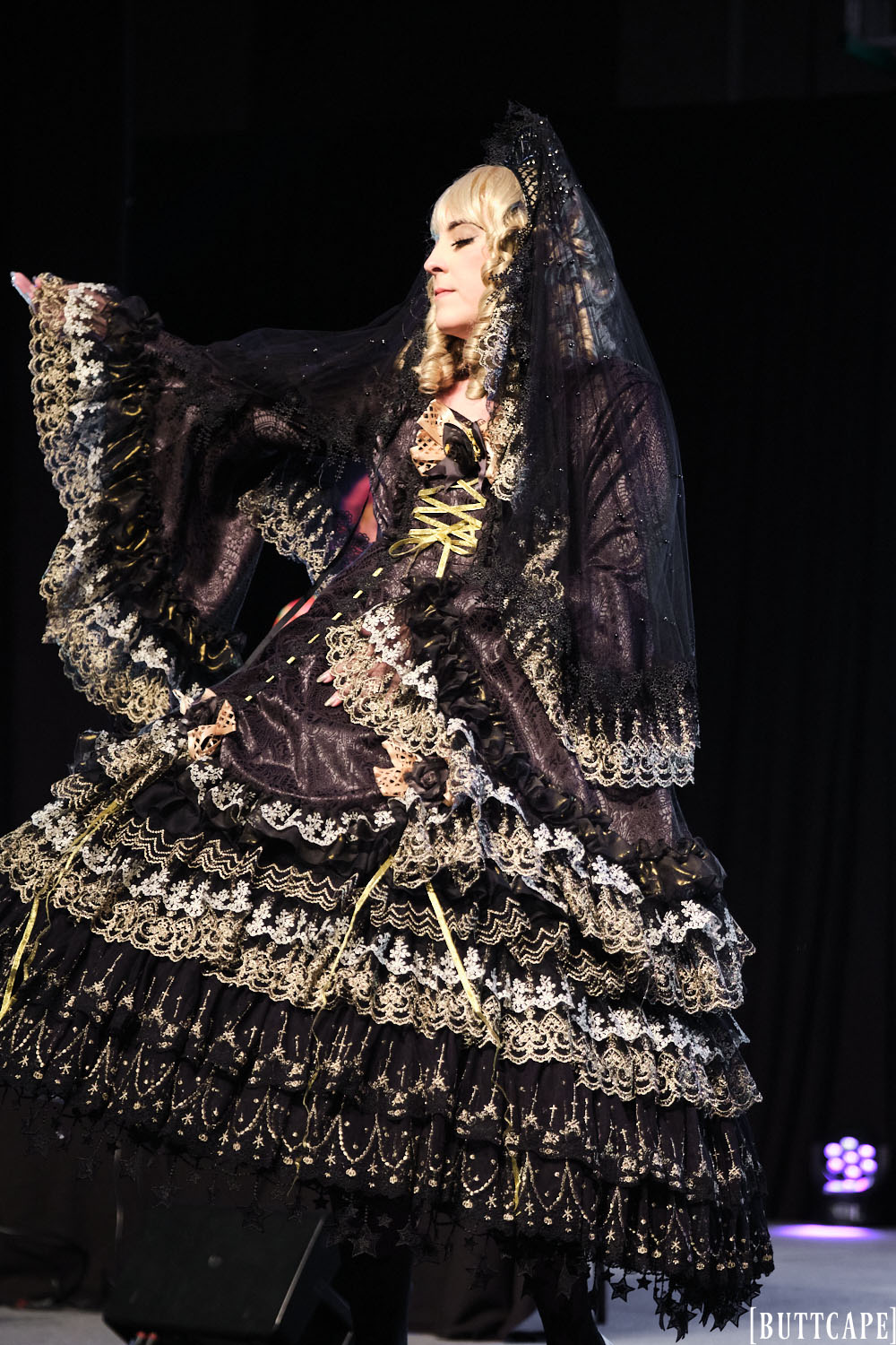 black and gold gothic lolita model posing dramatically.