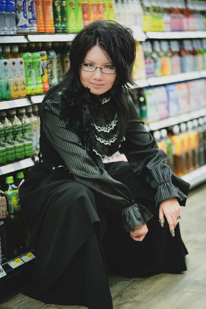 squatting in font of drinks aisle in grocery store, portrait orientation.