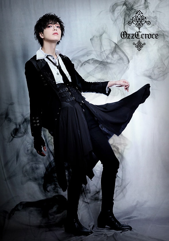 model wearing Ozz Croce outfit of whtie blouse, black jacket and skirt pants.