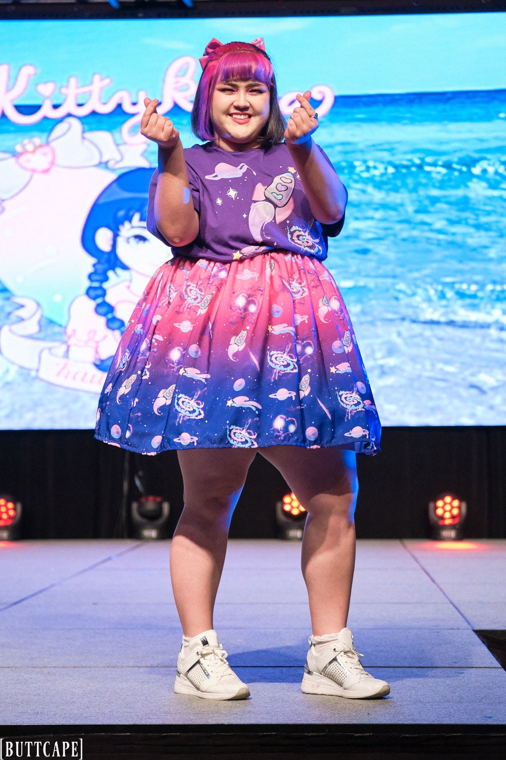 Kittykaya model wearing oversized purple space themed T-shirt, pink and navy gradient space themed skirt - full body 3.