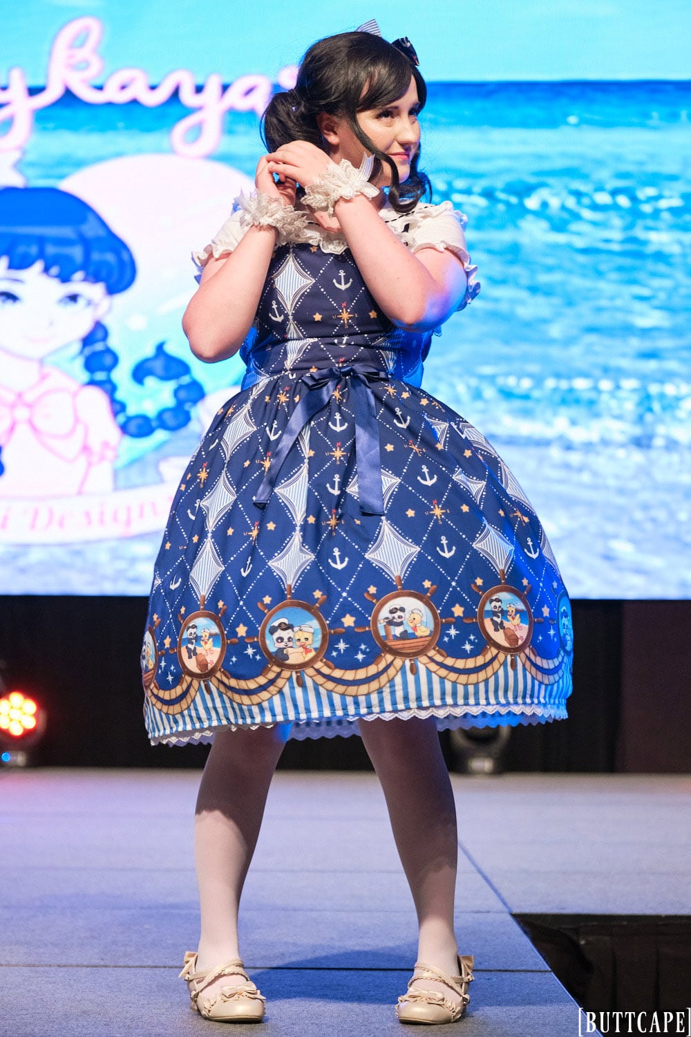 Kittykaya model 3 wearing blue sailor themed lolita dress with nautical animal theme - full body 2.