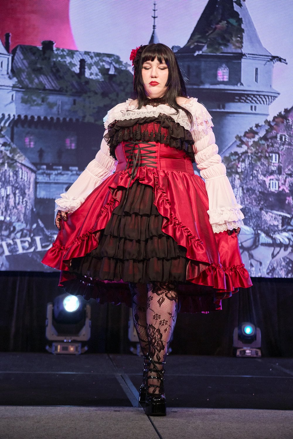 Plus size gothic lolita wearing red and black shantung bustle dress with white princess sleeve blouse, lace tights, and black shoes - full body 3.
