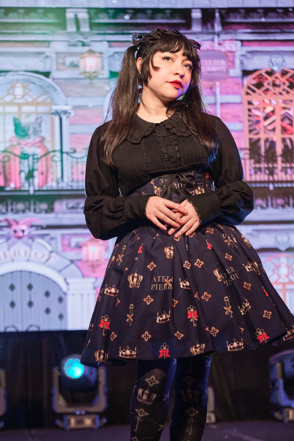 Classic lolita model wearing black cotton cutsew and navy high waist skirt with key print with matching tights - half body.
