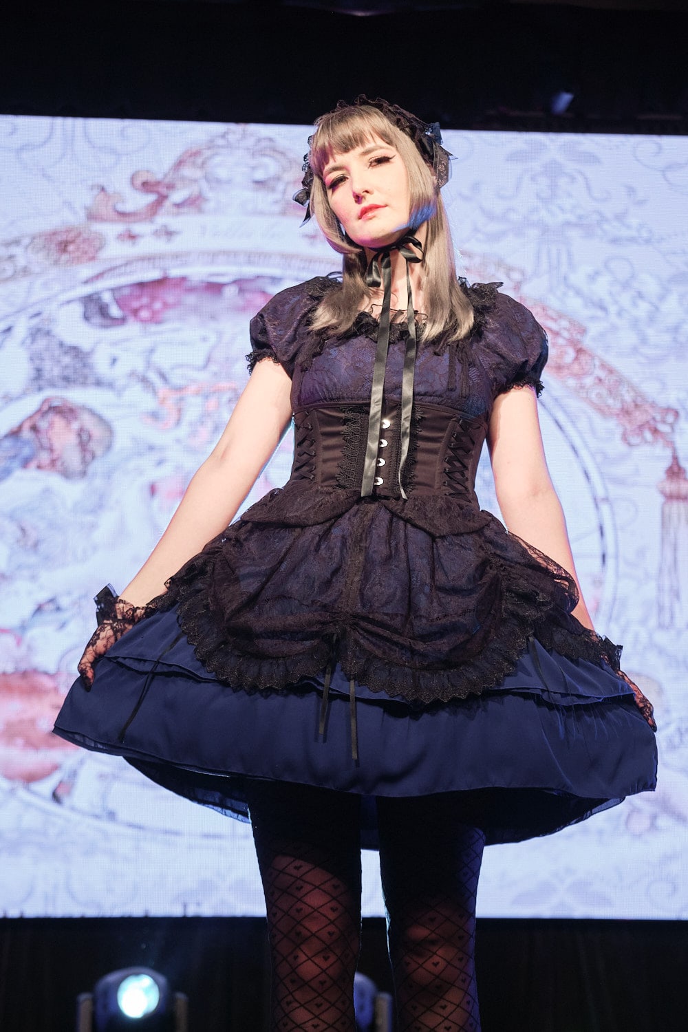 Gothic lolita wearing black and blue short sleeve dress with lace headdress and lace gloves - closeup 2.