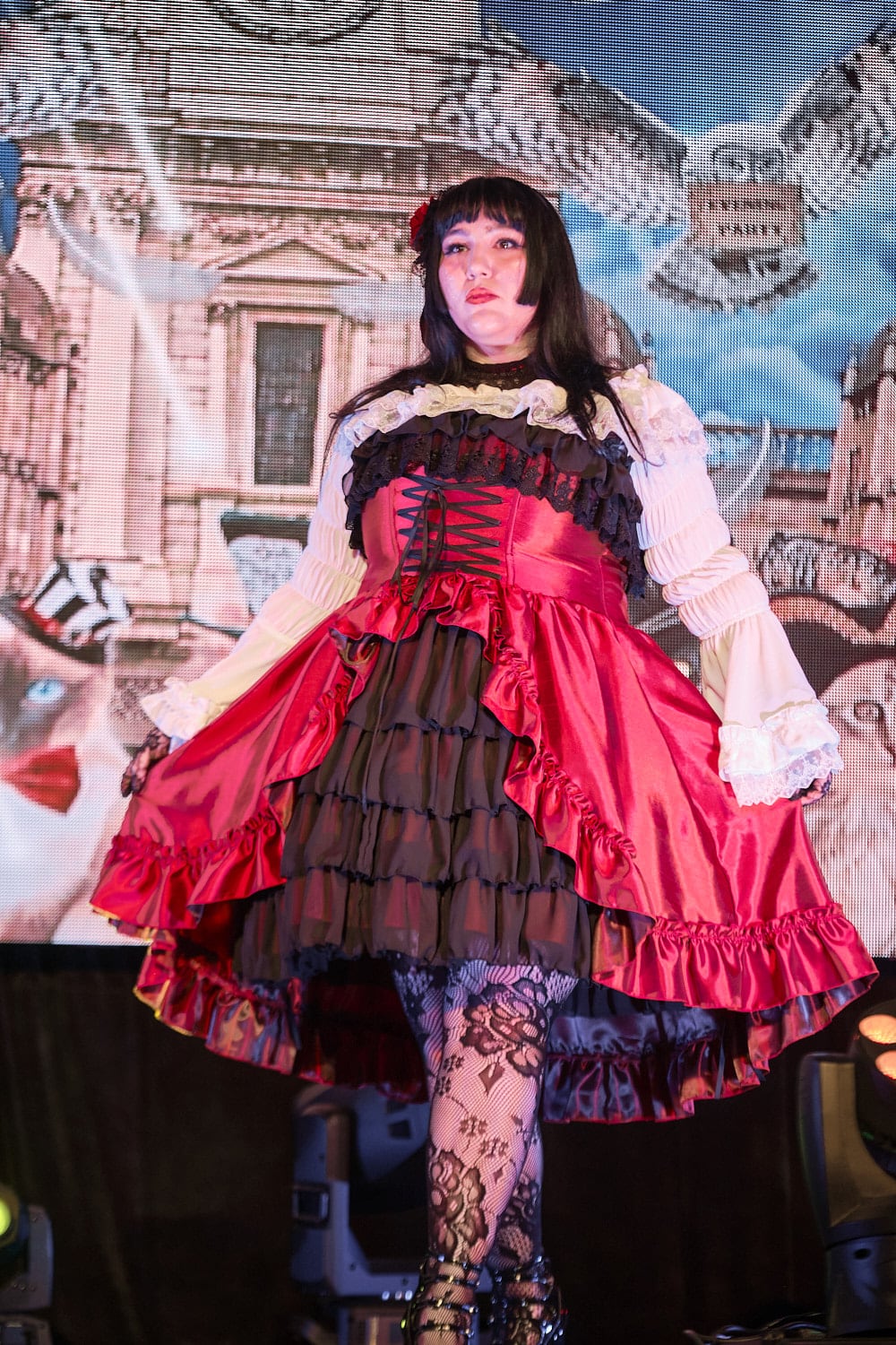 Plus size gothic lolita wearing red and black shantung bustle dress with white princess sleeve blouse, lace tights, and black shoes - closeup 2.