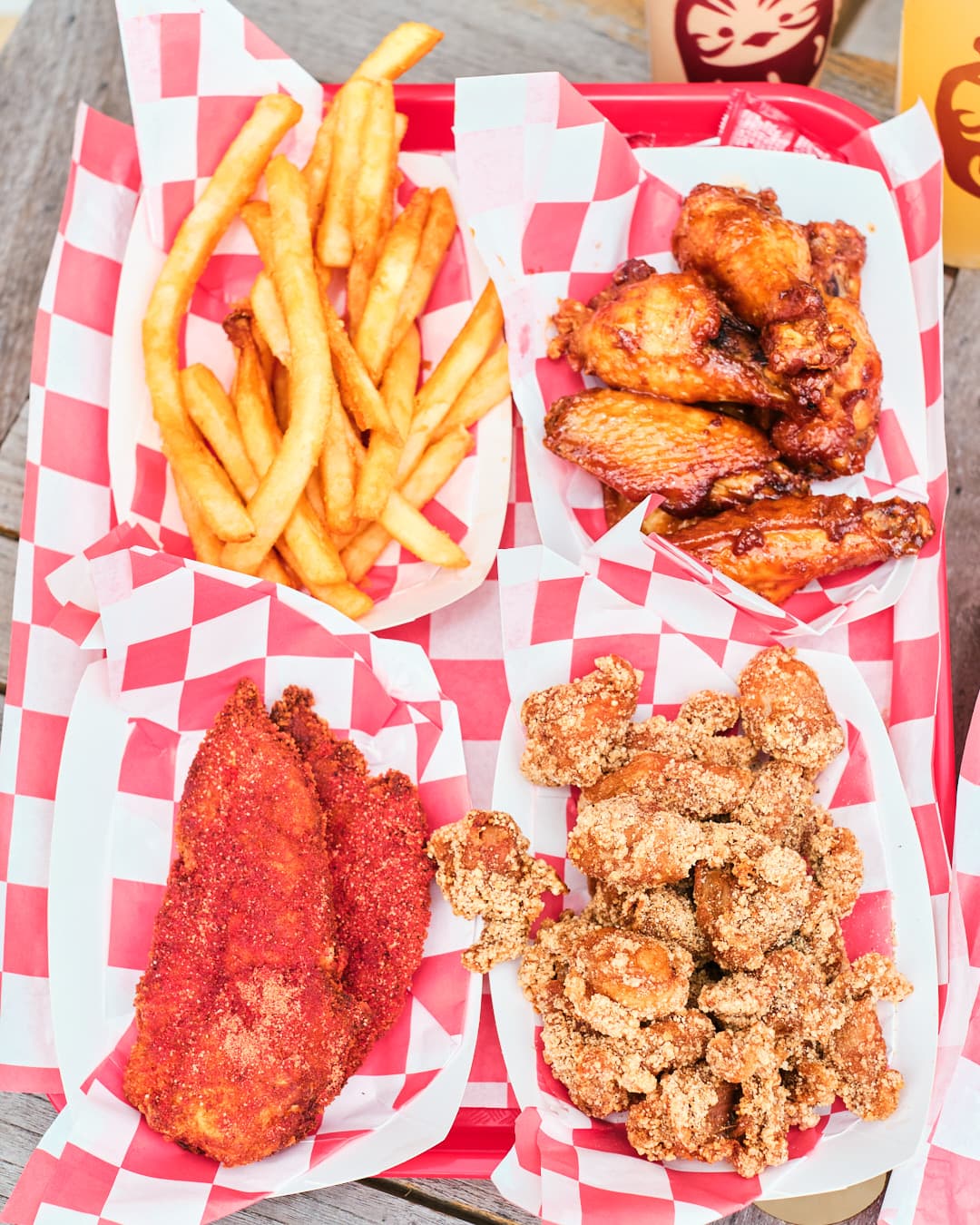 overhead shot of tray with french fries, chicken wings, chicken tenders, and popcorn chicken.