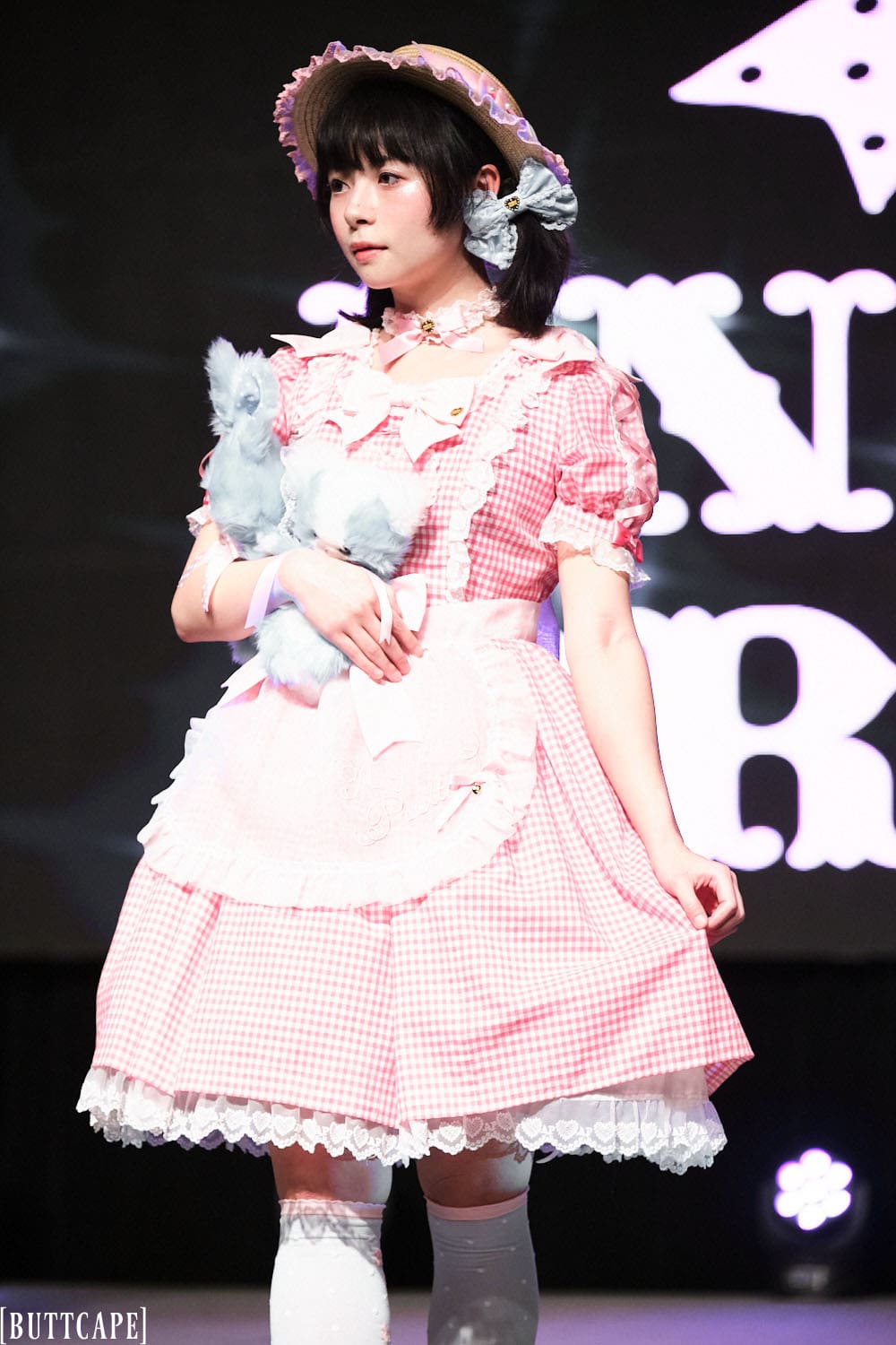 Model 11 wearing pink and white gingham lolita dress and boater hat holding two stuffed animals - half body 3.