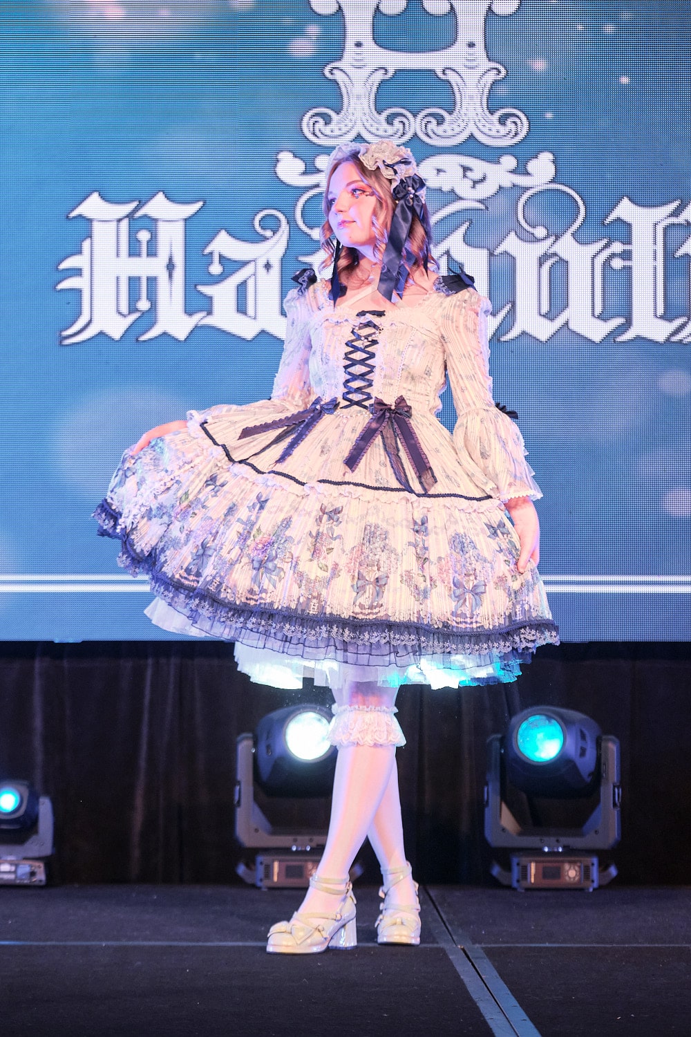 Model 8 wearing white and navy hydrangea print princess sleeves one piece dress with matching headdress, white lace knee socks, and white shoes - full body 2.