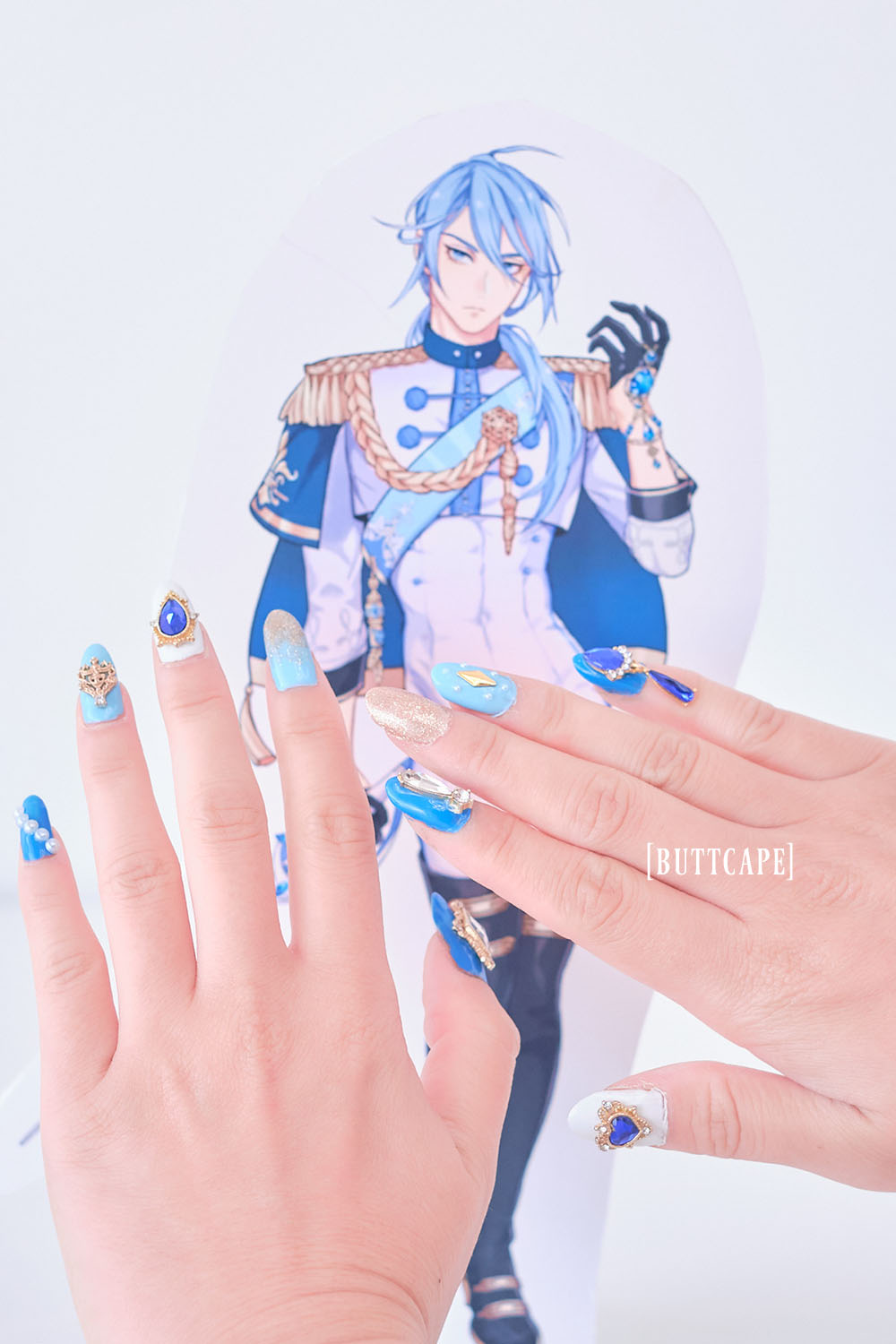 Two hands showing off nails in front of Nu:Carnival character Edmond.