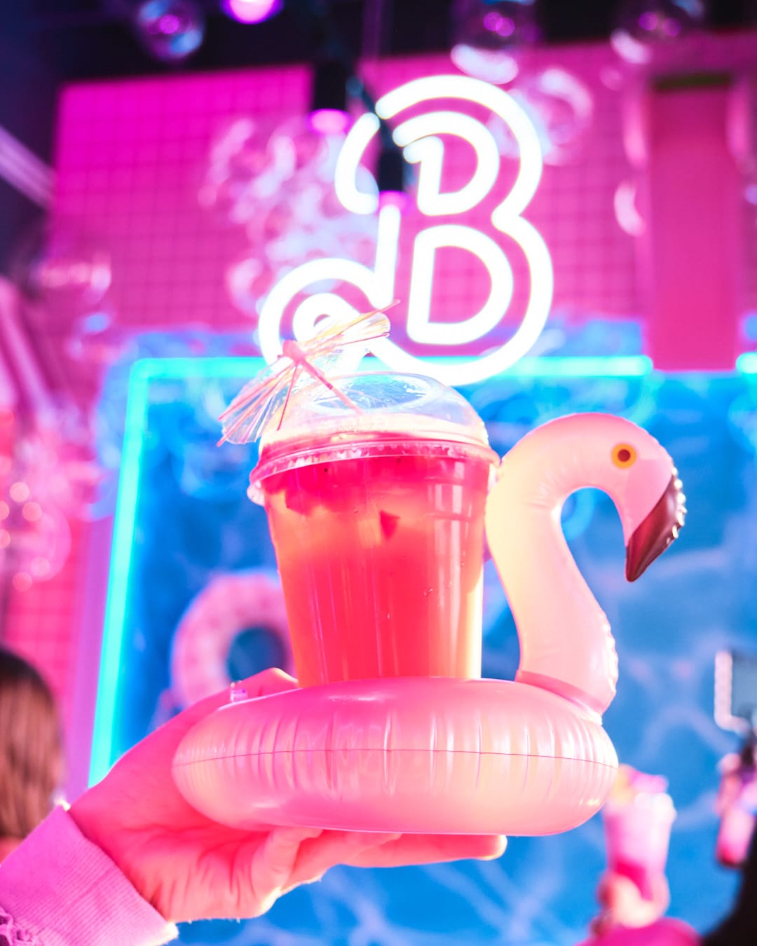 Pink drink in flamingo inflatable cup holder.