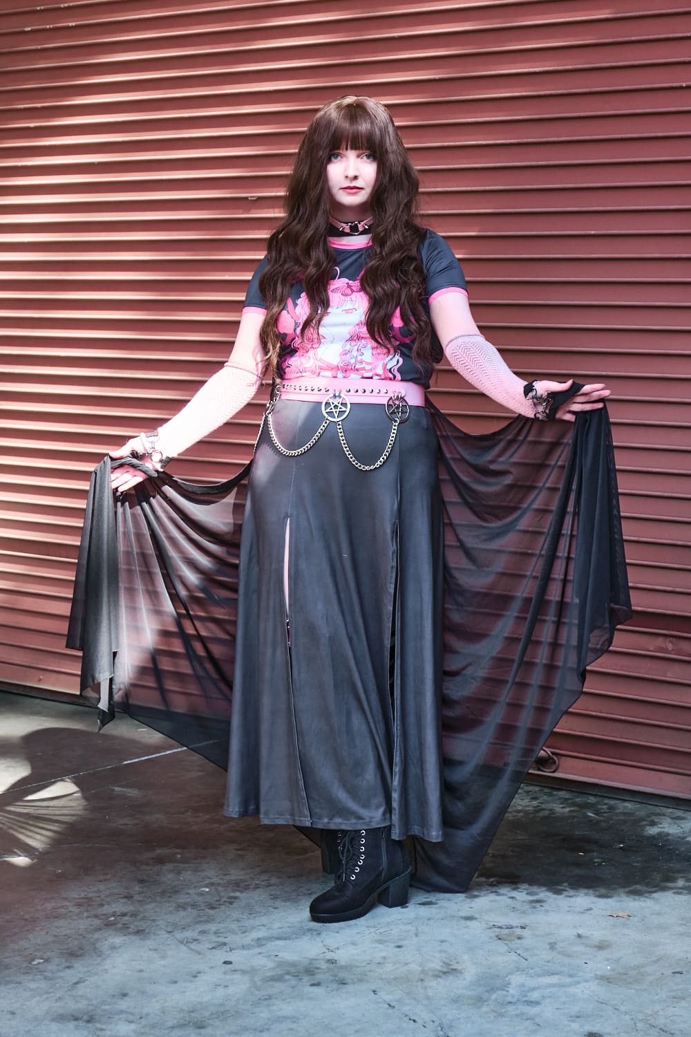 Gothic model wearing black and pink printed T-shirt and slit skirt with pink chain belt - full body pose 2.