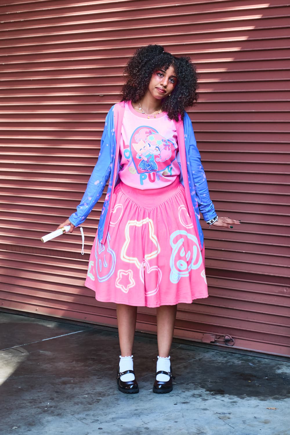 Cute model wearing blue and pink cardigan with pink heart T-shirt and pink circle skirt with neon light motifs - full body pose 4.