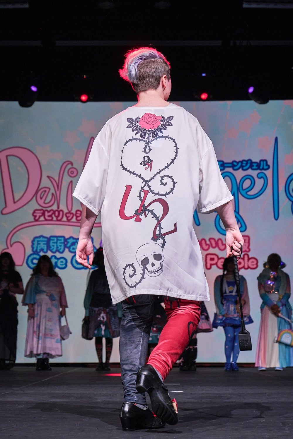 Punk model wearing baggy T-shirt with anime styled couple with bloody print leggings - full body backside. Back of shirt has thorn vine in the shape of a heart and the phrase "U2".