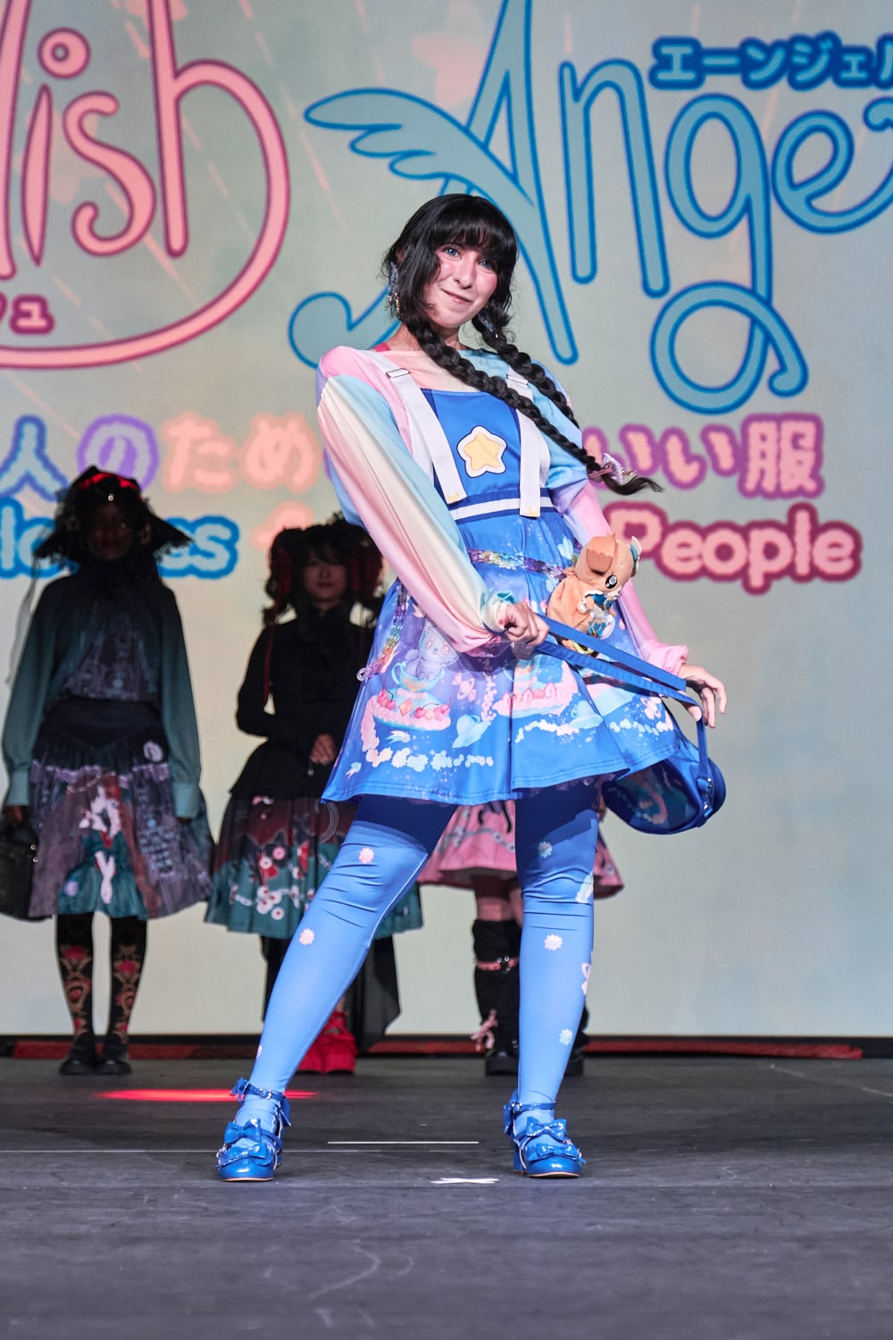 Model wearing bright blue top, knee skirt, and leggings featuring cats and star motifs - full body pose 1.