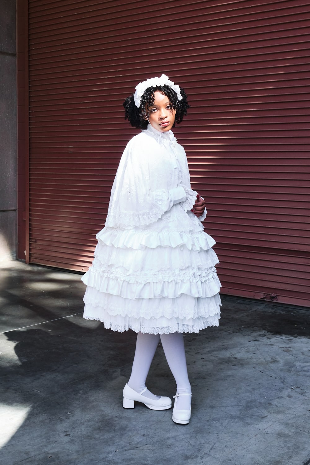 Atelier Pierrot classic lolita model wearing an all white collaboration set of a lace capelet and dress set - full body standing pose 5.