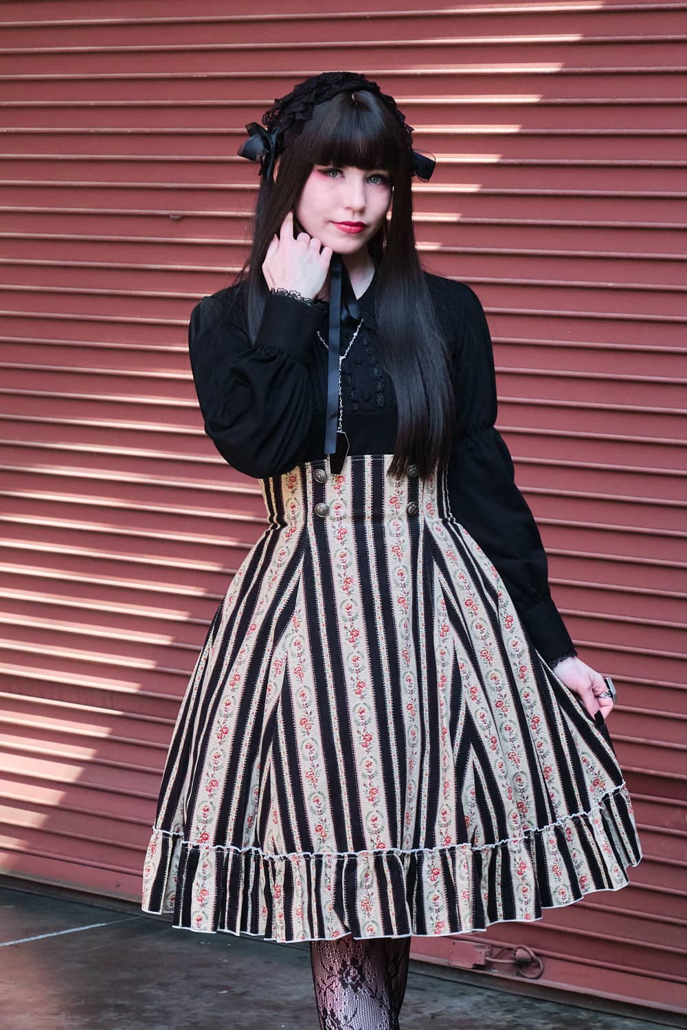Atelier Pierrot classic lolita model wearing black long sleeve cutsew and floral pattern high waist skirt - portrait.