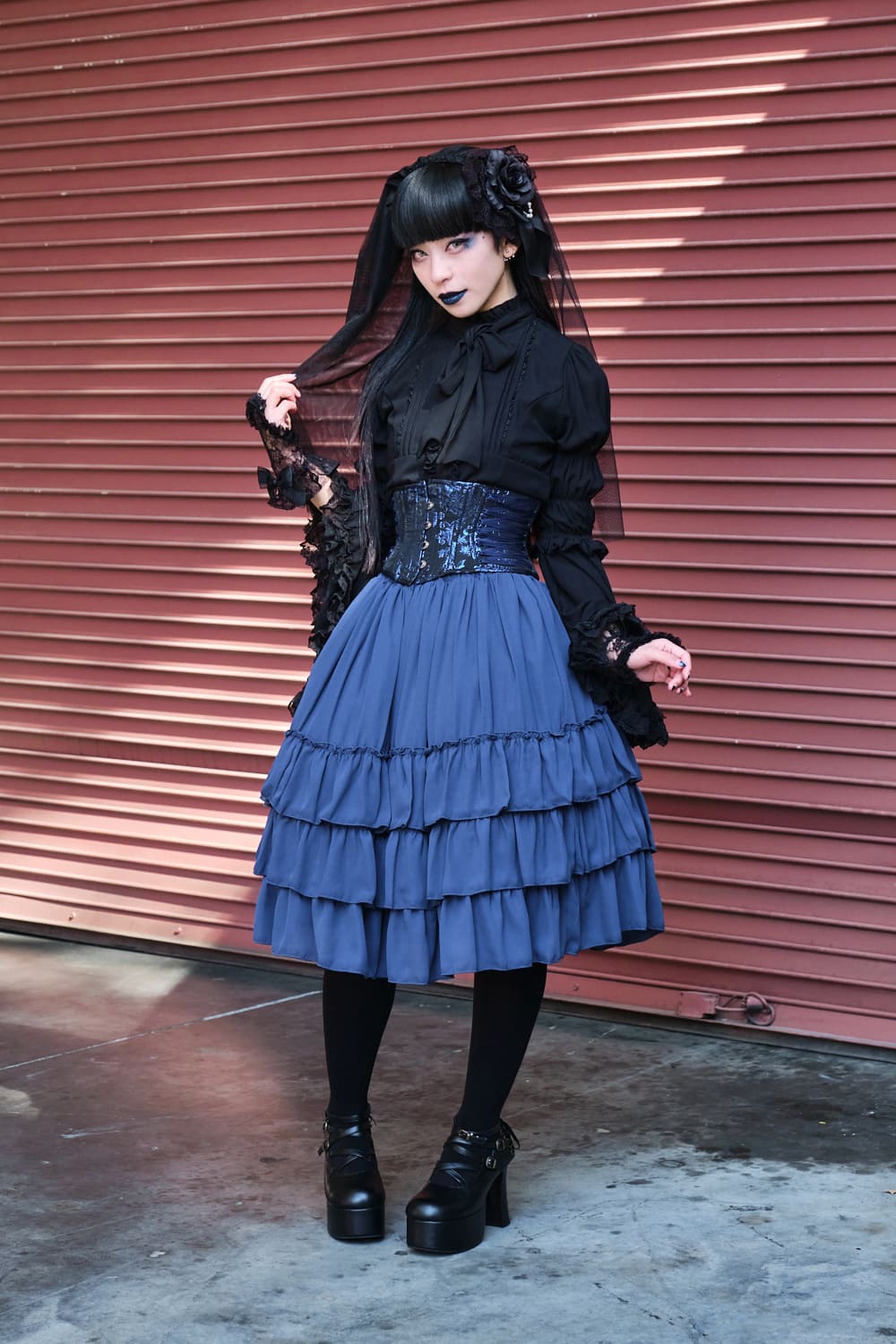 Atelier Pierrot gothic lolita model wearing black blouse, blue corset and skirt - full body standing pose 5.
