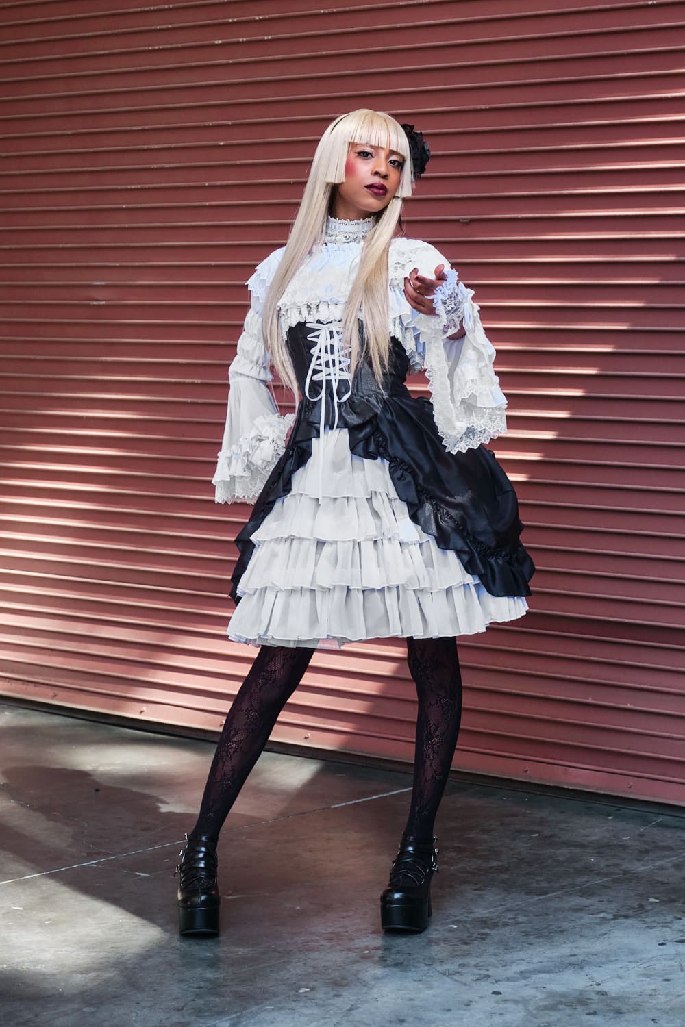 Atelier Pierrot gothic lolita model wearing black and white bustle corset jumperskirt with white princess sleeve blouse - full body standing pose 5.