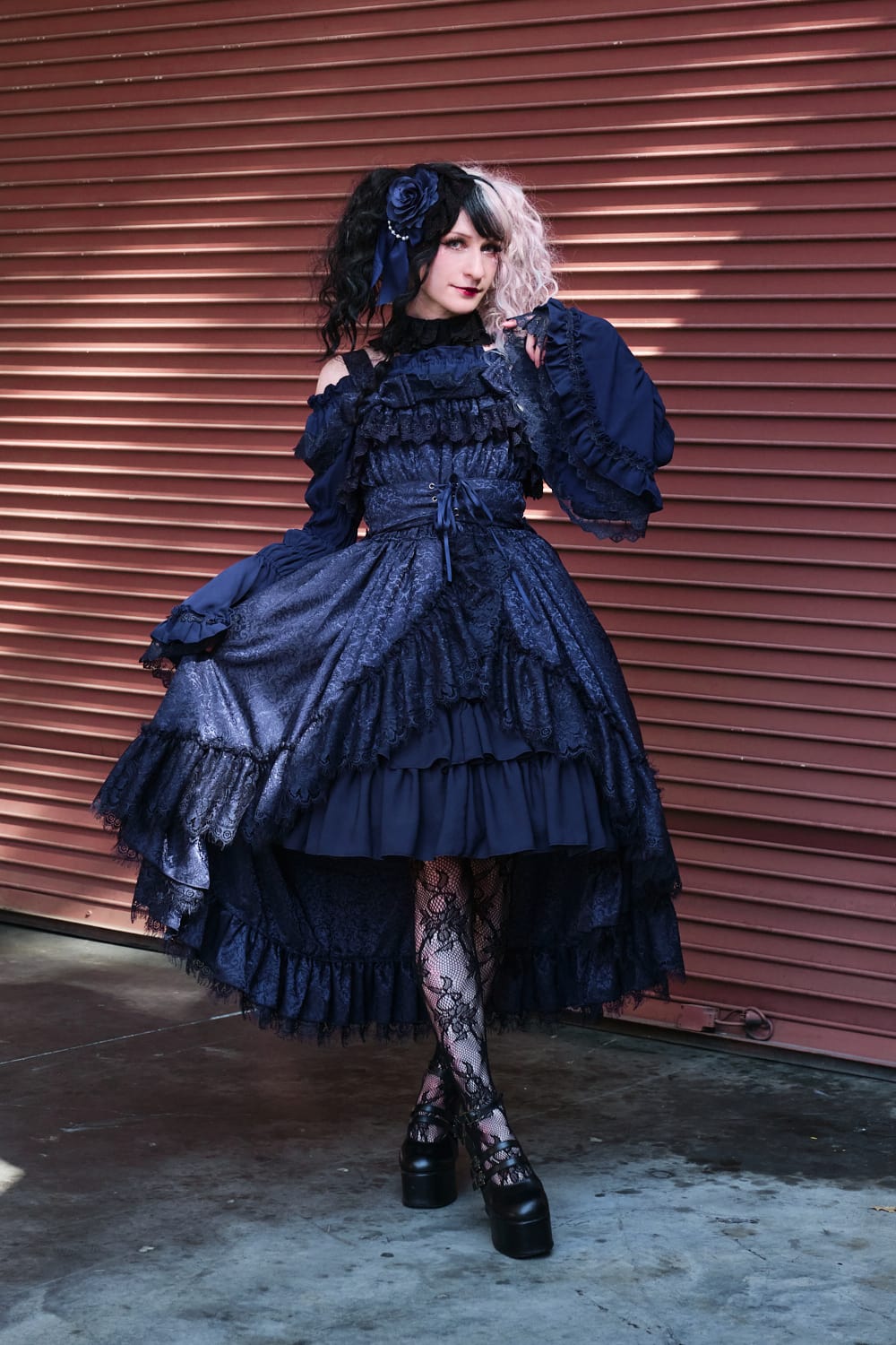 Atelier Pierrot gothic lolita model wearing all navy lace high low fishtail jumperskirt and navy princess sleeve blouse - full body standing pose 6.