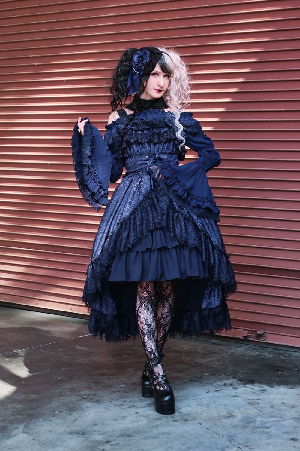 Atelier Pierrot gothic lolita model wearing all navy lace high low fishtail jumperskirt and navy princess sleeve blouse - full body standing pose 10.