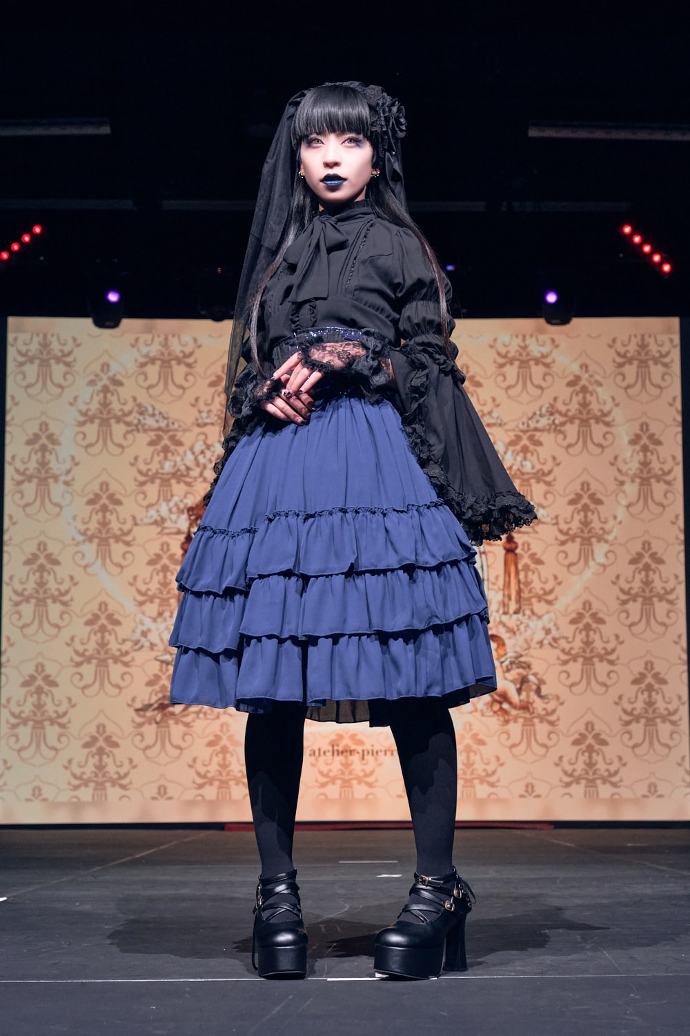 Atelier Pierrot gothic lolita model wearing black blouse, blue corset and skirt - full body standing pose 2.
