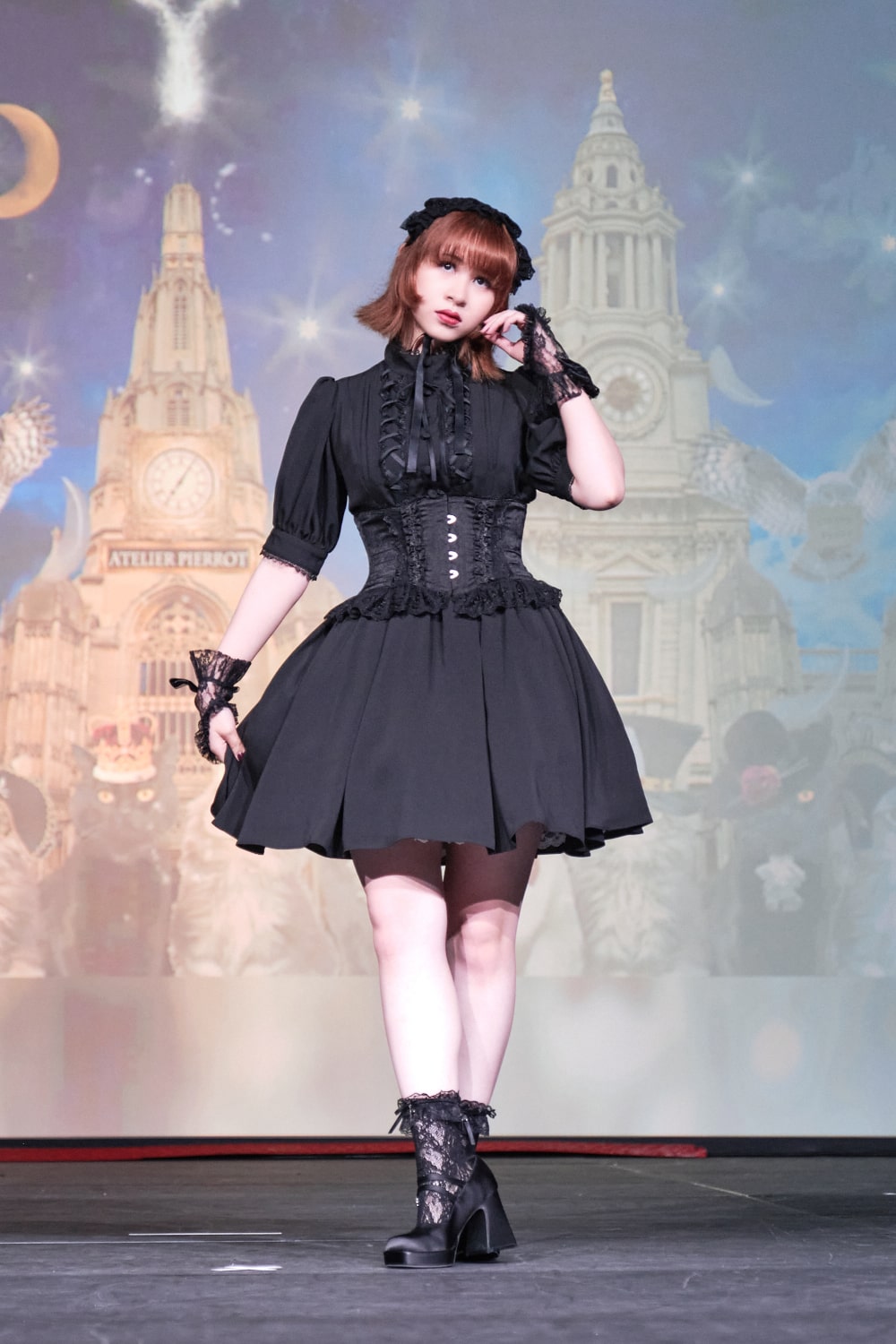 Atelier Pierrot gothic lolita model wearing all black short sleeved dress with black corset - full body standing pose 1.