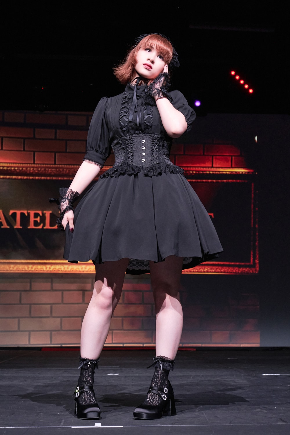 Atelier Pierrot gothic lolita model wearing all black short sleeved dress with black corset - full body standing pose 3.