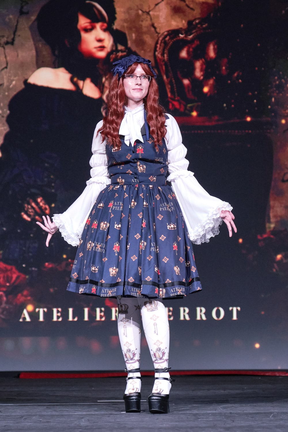 Atelier Pierrot classic lolita model wearing white princess sleeve blouse with crown print vest-style jumperskirt and matching crown tights - full body standing pose 2.