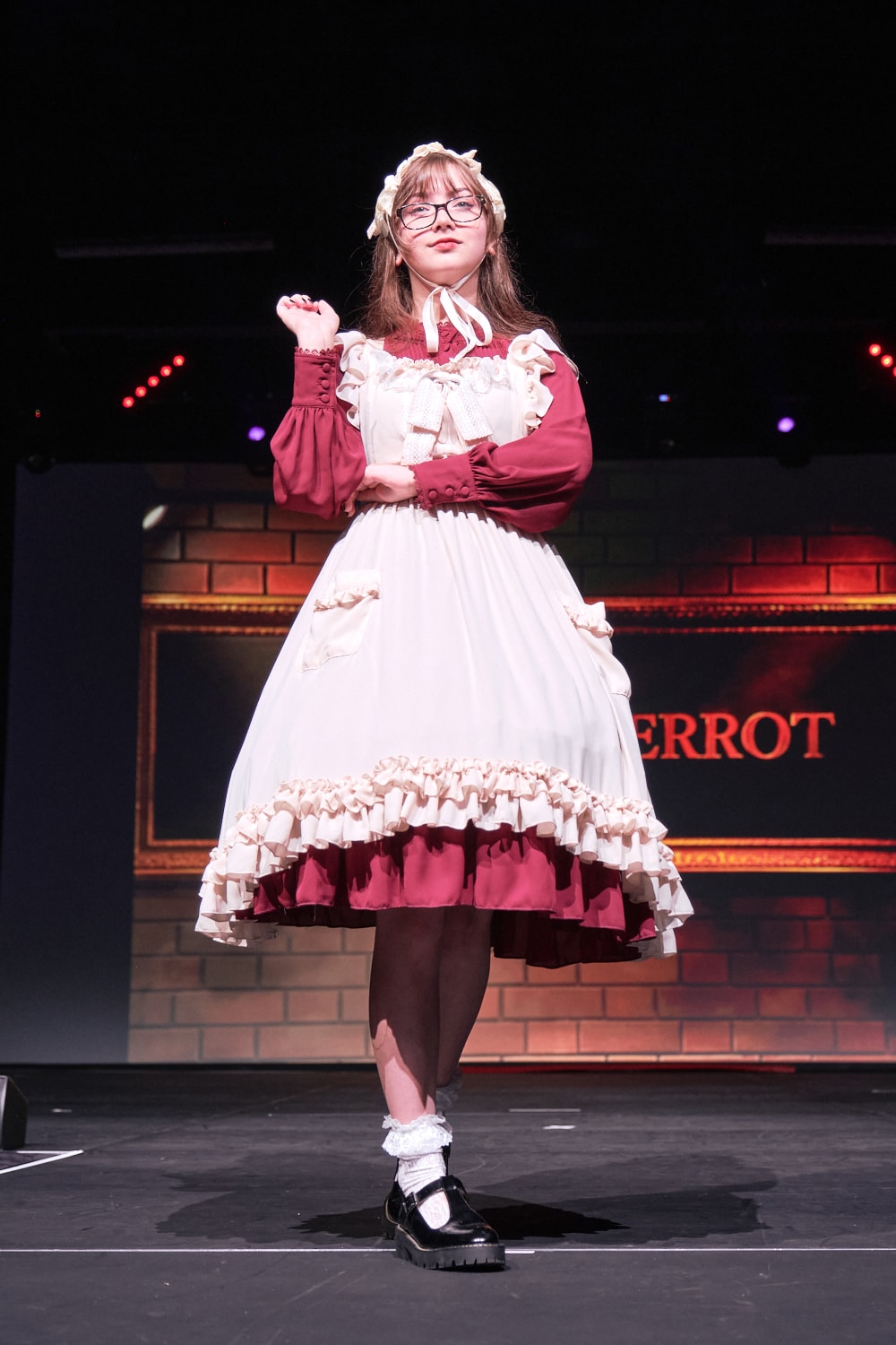 Atelier Pierrot classic lolita model wearing wine red long sleeve one piece dress with ivory apron on top - full body standing pose 3.