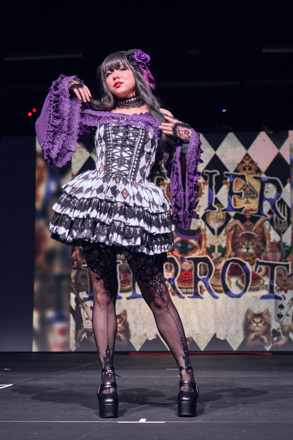 Atelier Pierrot gothic lolita model wearing purple princess sleeve blouse with black and white diamond print mini corset dress - full body standing pose 2.