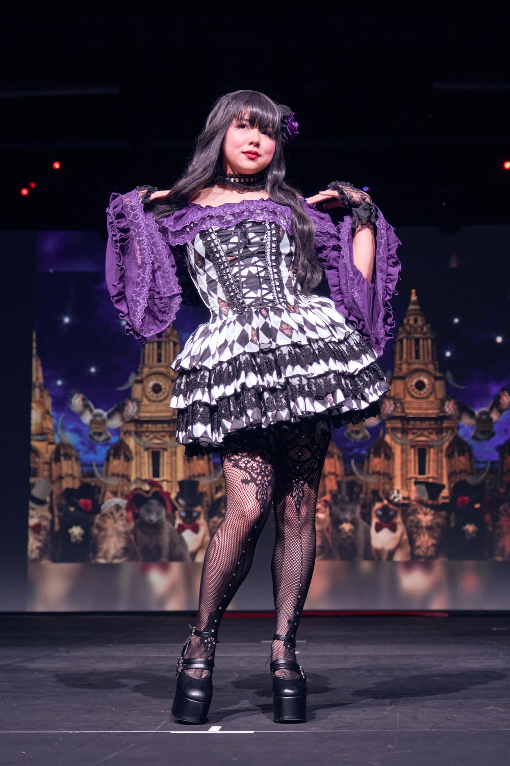 Atelier Pierrot gothic lolita model wearing purple princess sleeve blouse with black and white diamond print mini corset dress - full body standing pose 3.