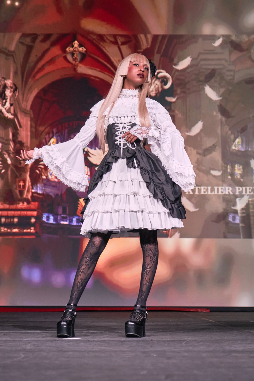 Atelier Pierrot gothic lolita model wearing black and white bustle corset jumperskirt with white princess sleeve blouse - full body standing pose 2.