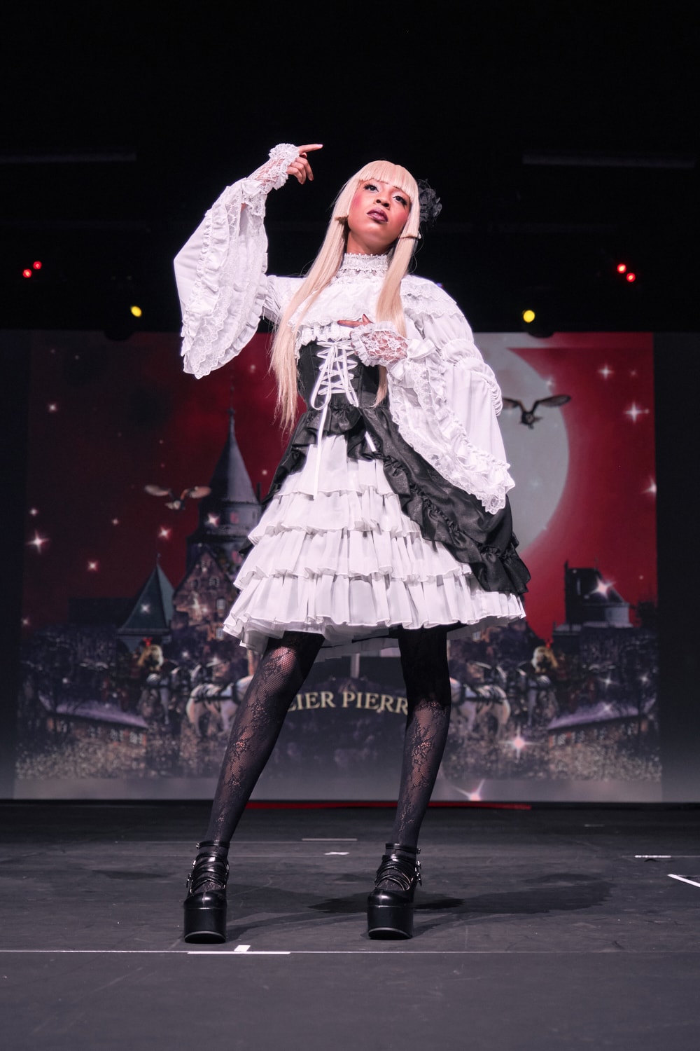 Atelier Pierrot gothic lolita model wearing black and white bustle corset jumperskirt with white princess sleeve blouse - full body standing pose 3.