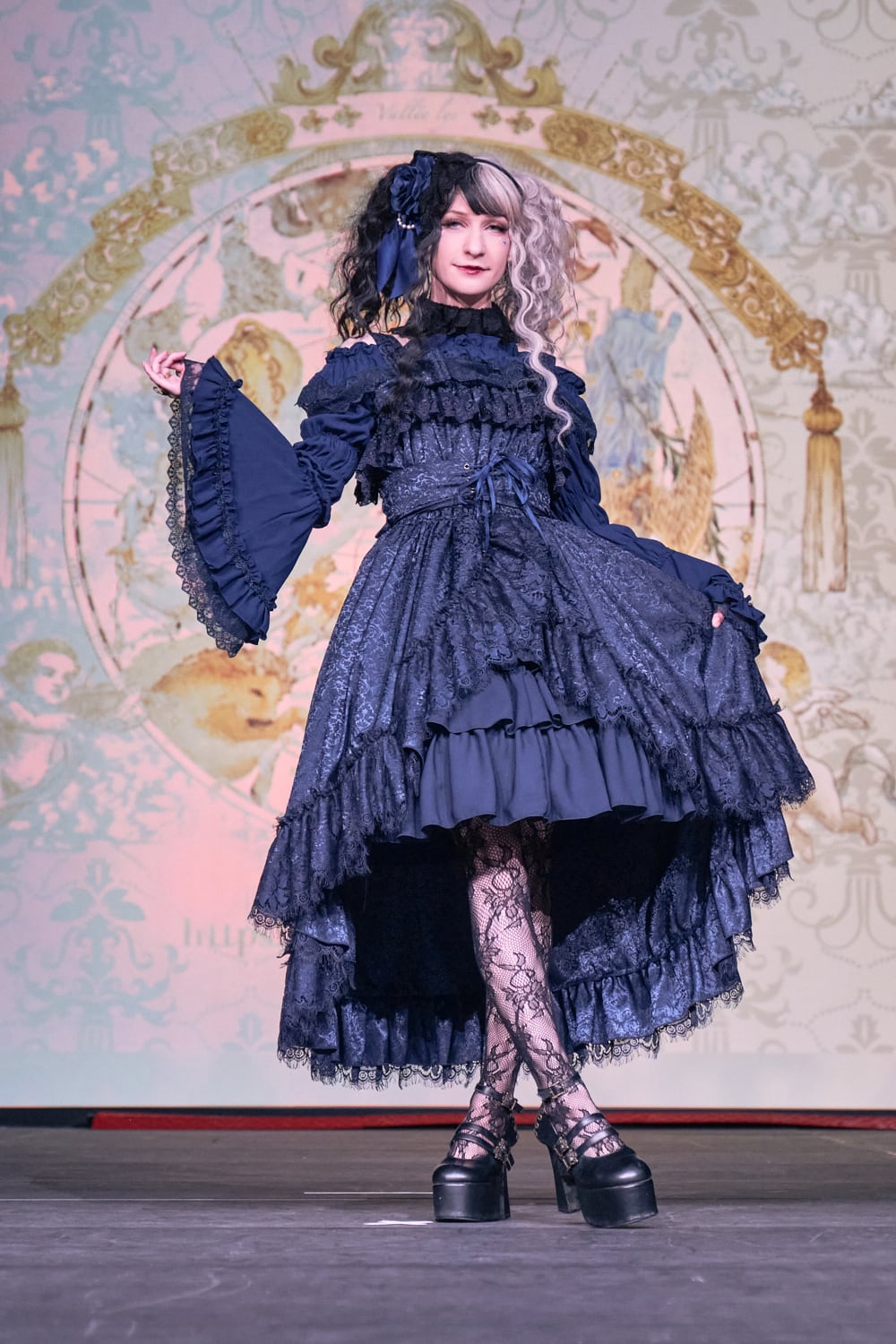 Atelier Pierrot gothic lolita model wearing all navy lace high low fishtail jumperskirt and navy princess sleeve blouse - full body standing pose 3.