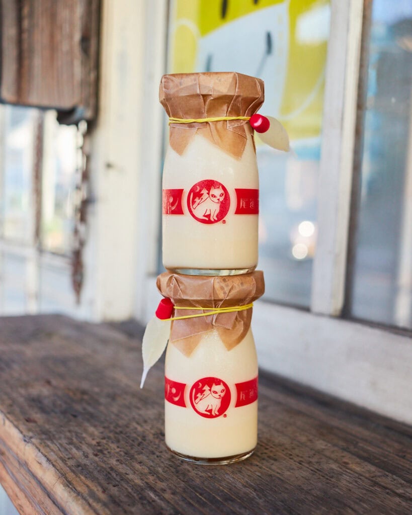 Hassaku orange pudding in a small milk jar stacked on top of each other
