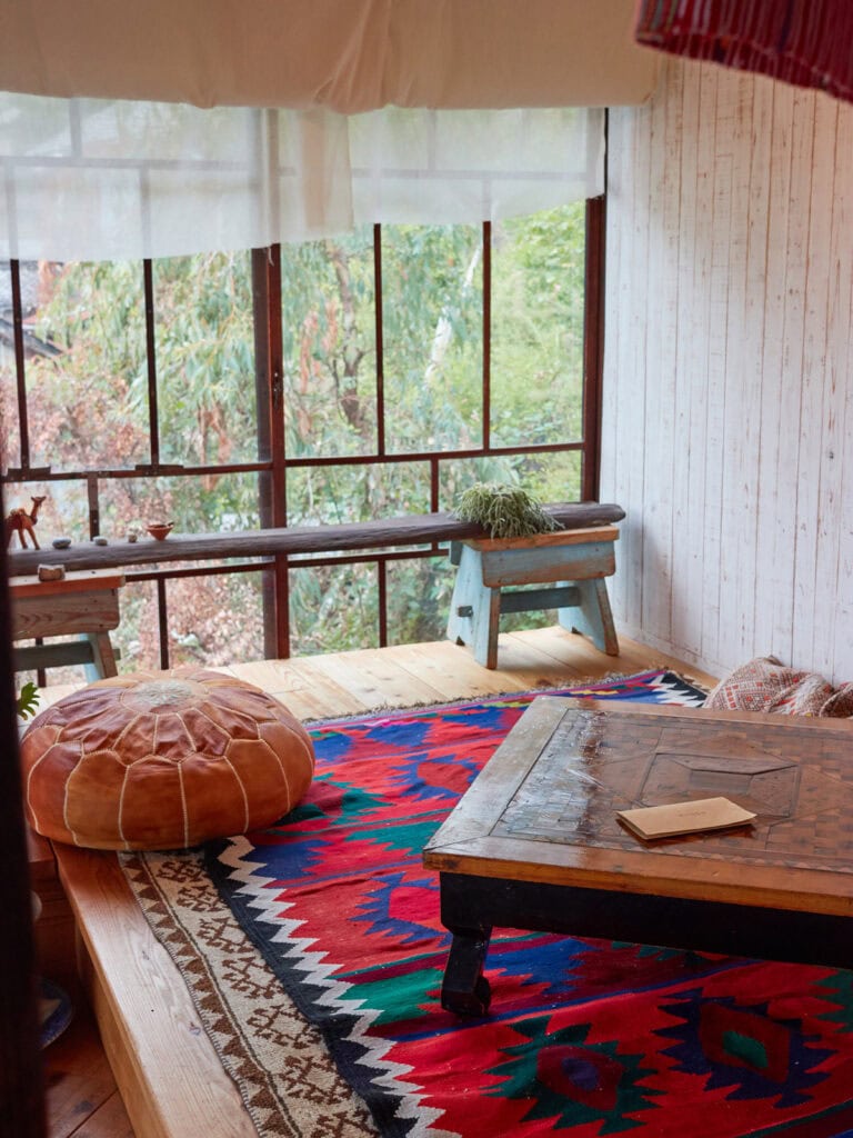 Floor seating in a boho style room along a window in an old Japanese house