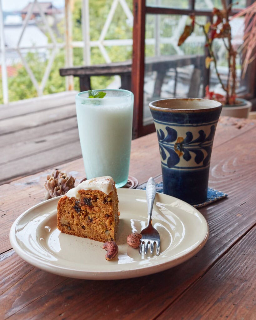 Carrot cake, lassi, and chai with a view of nature