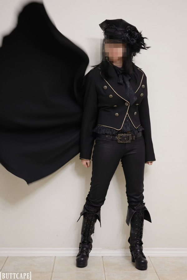 Military themed outfit with billowing cape on jacket, skinny pants, and pirate boots.