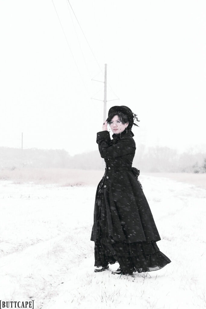 Standing in snow field looking into the distance.