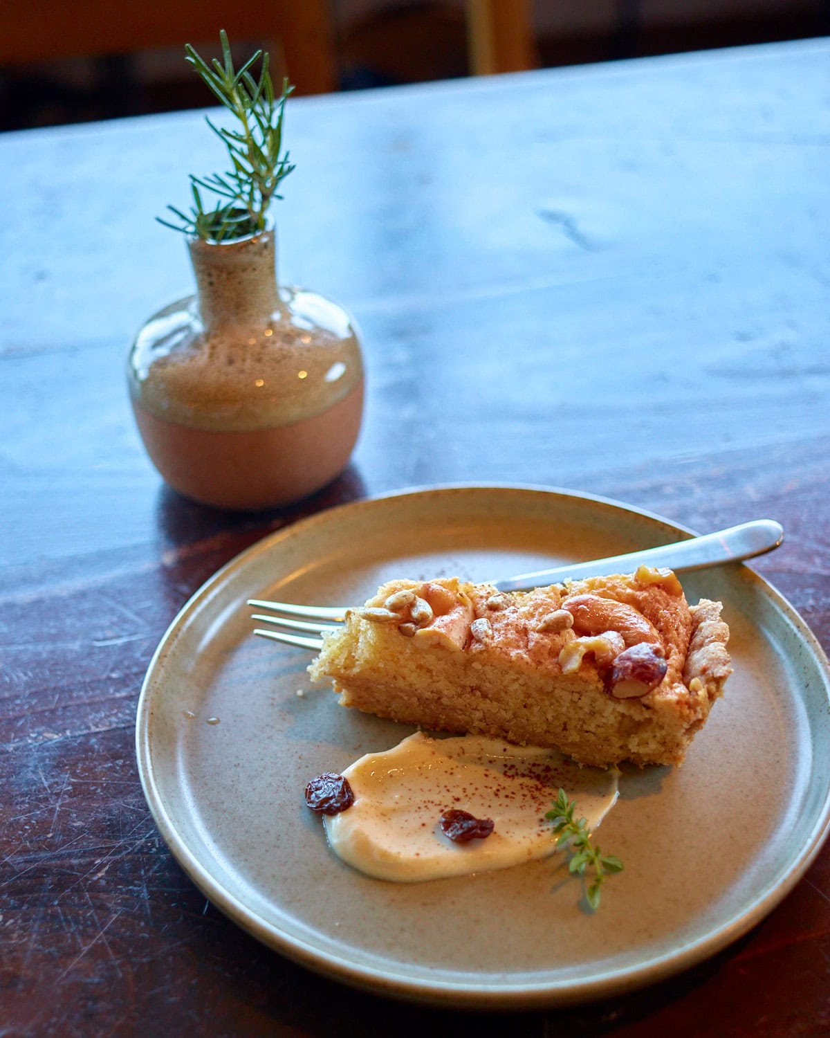 Veg Out Kyoto 3 Nut Tart with cream spread on small plate with a fork