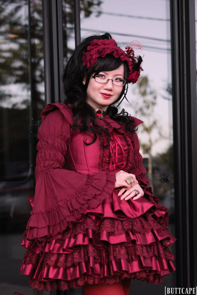 Half body shot of outfit standing in front of black glass doors.