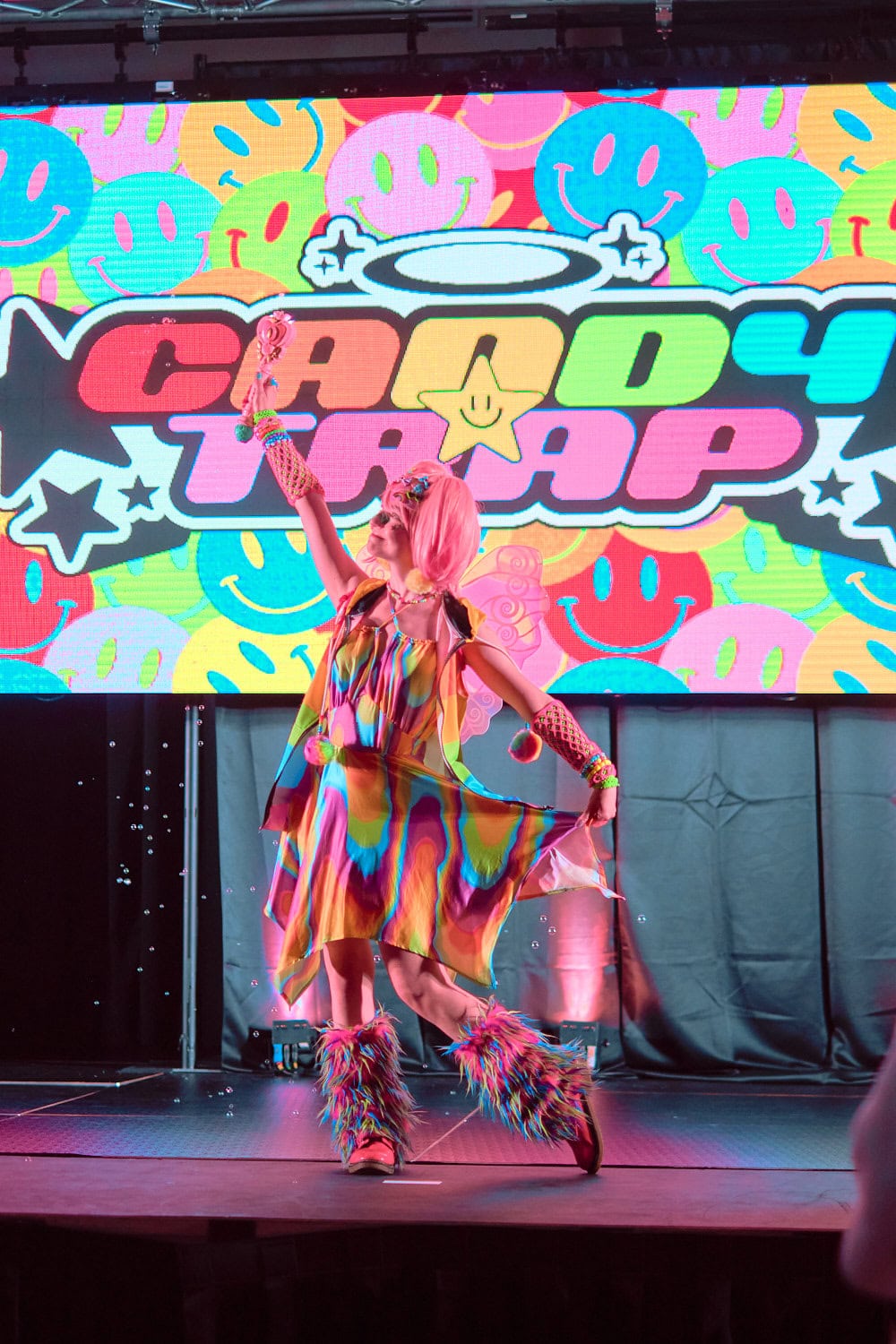 Candy Trap model #1 holding out the skirt of a tie dye style flare dress.
