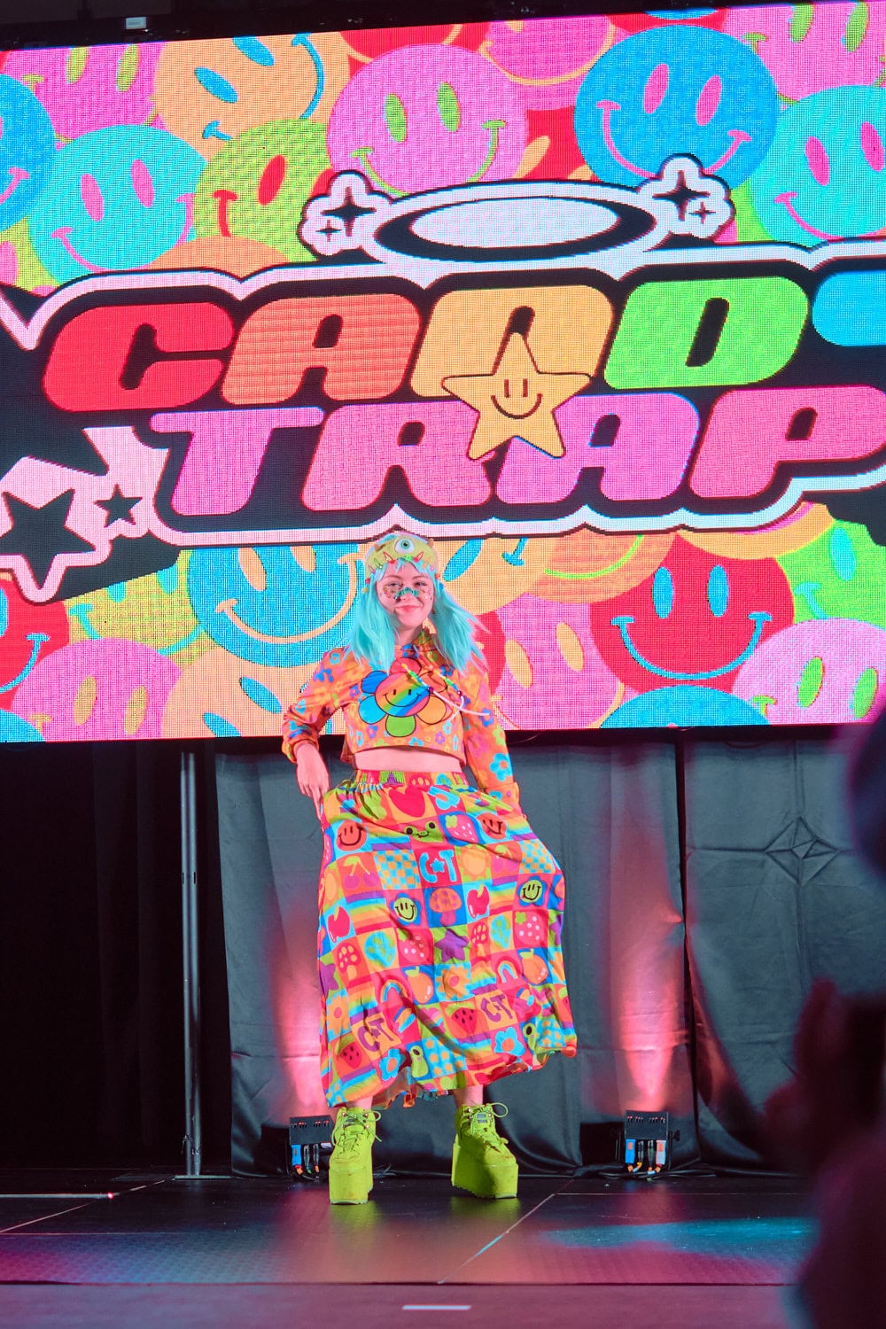 Candy Trap model #3 wears rainbow flower crop top with multicolor grid baggy pants.