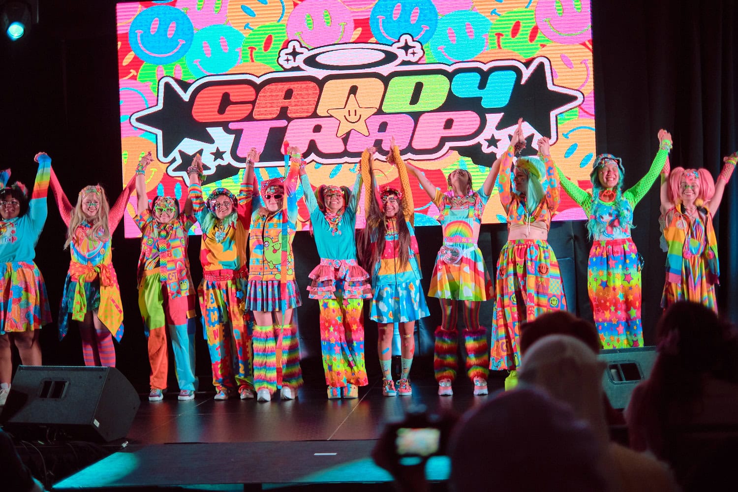 Candy Trap designer posing on stage and raising hands with all models.