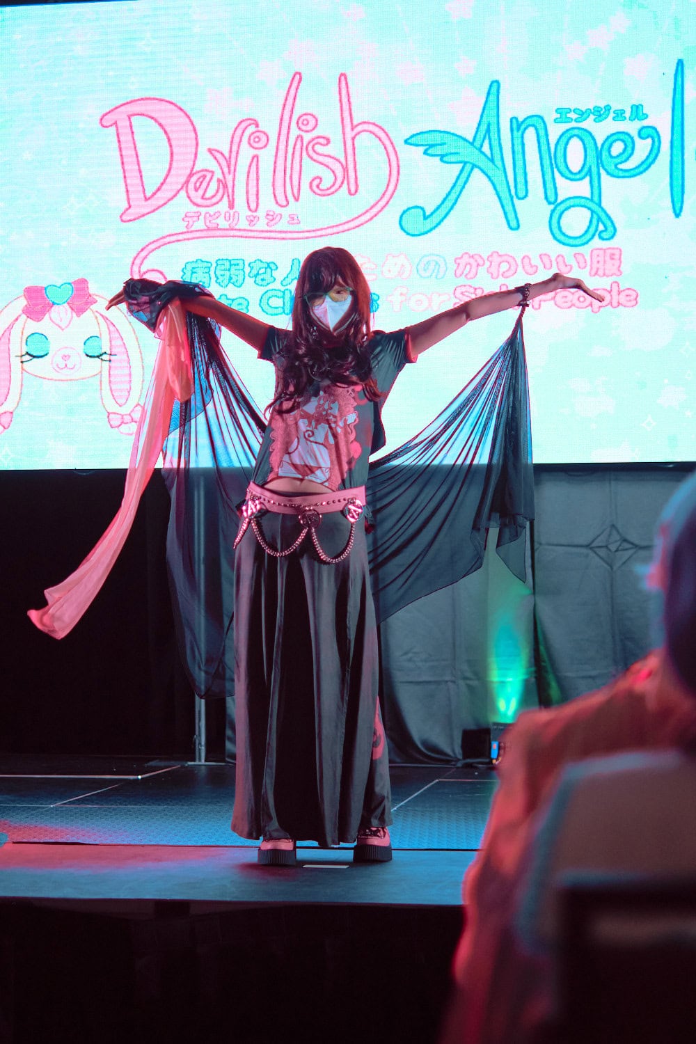 Devilish Angel model #7 wears black anime girl t-shirt, maxi skirt, and chiffon scarves attached to hands.