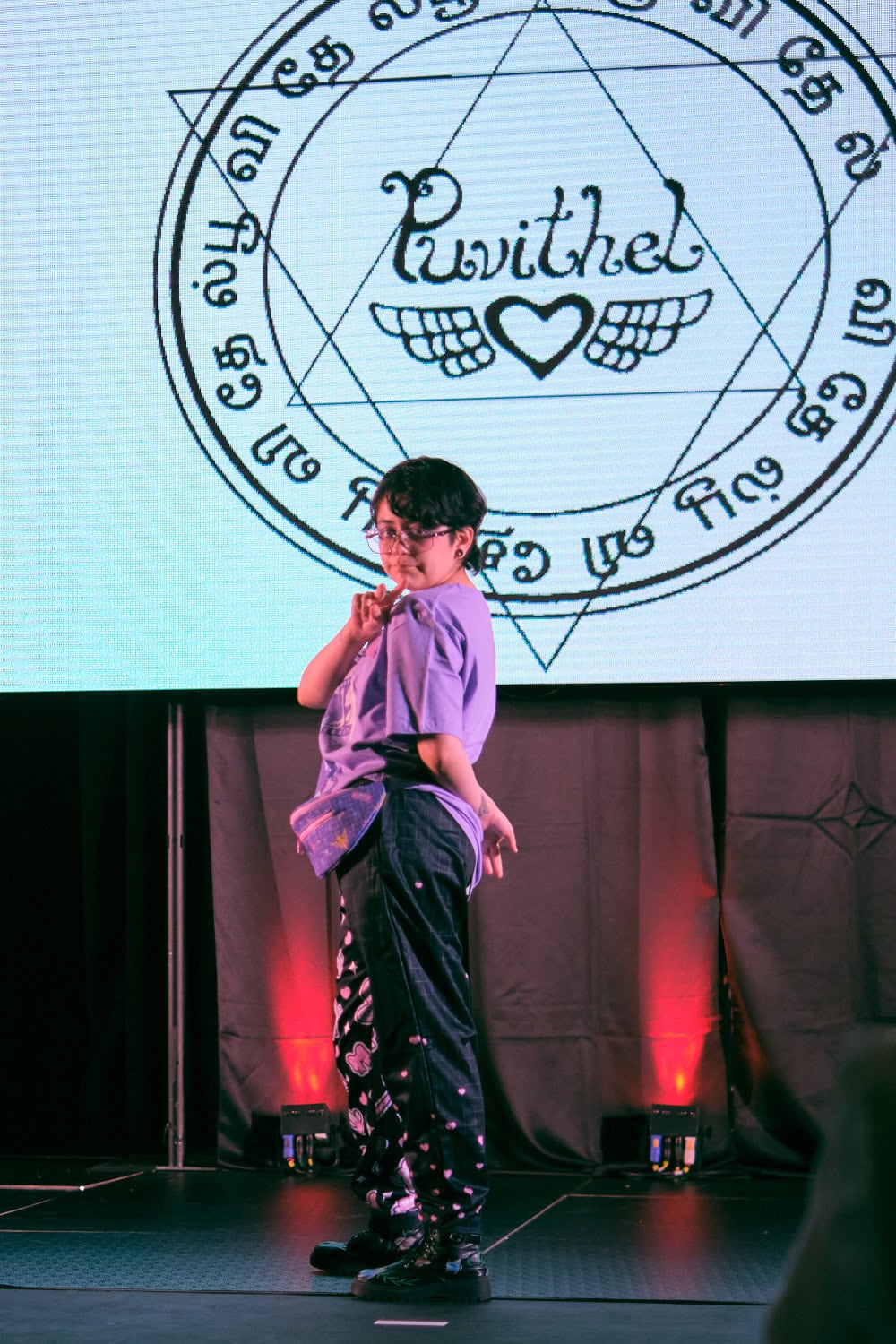 Puvithel model #4 wears lavender t-shirt with pill print cargo pants.