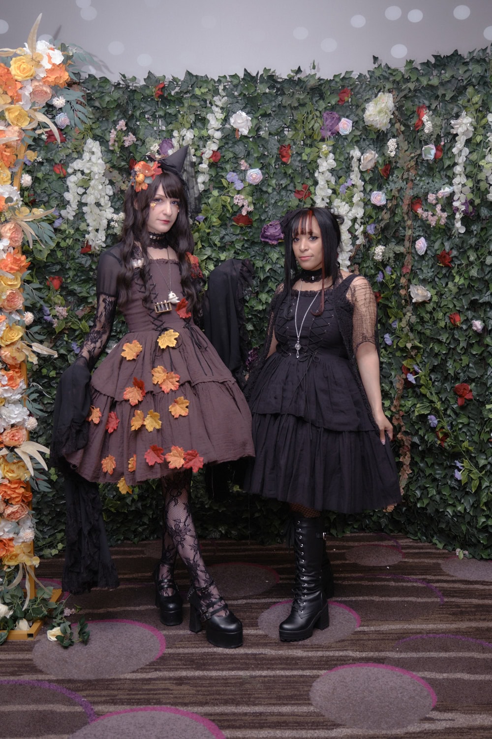Two gothic lolitas standing next to each other.